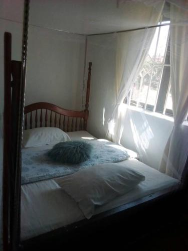 a bed sitting in a bedroom with a window at Rena Akasha Establishments in Kyenjojo
