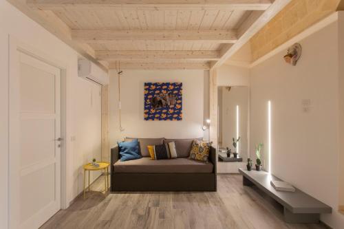- un salon avec un canapé et un tableau mural dans l'établissement Lo Strazzo - Comfort Rooms, à Matera