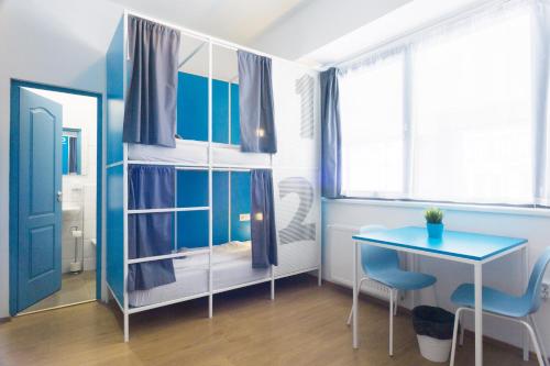 um quarto azul com uma secretária e uma mesa em Absolut City Hostel em Budapeste