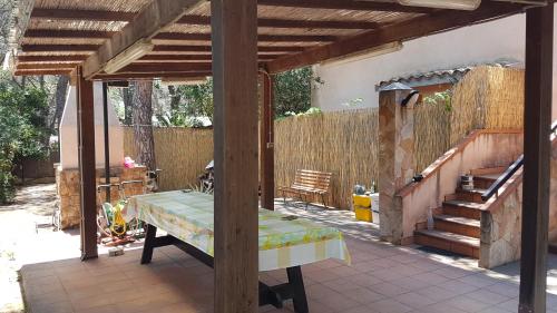 a patio with a bench and a wooden pergola at Mare a Santa Margherita in Pula