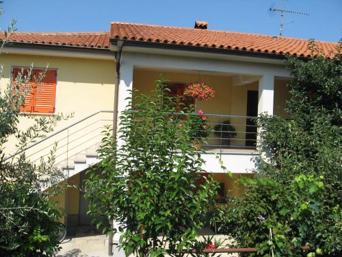 a house with a balcony with flowers in the window at Apartments Tomišić in Koper