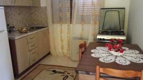 una piccola cucina con tavolo e specchio di Guesthouse Fatos Biti a Divjakë