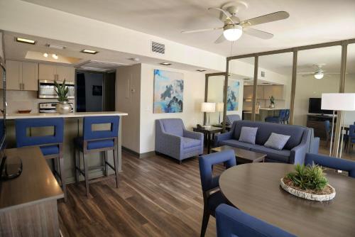 a living room with blue chairs and a table at The Dover House Resort in Delray Beach