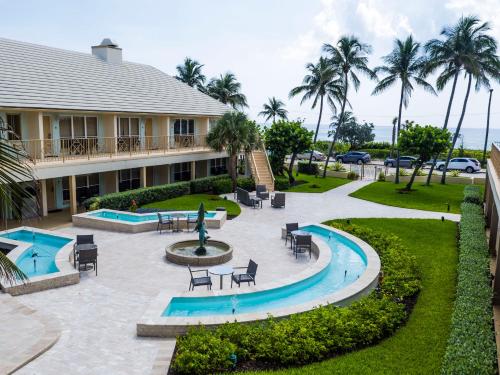 un complejo con piscina y patio con mesas y sillas en The Dover House Resort, en Delray Beach