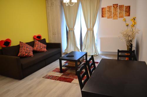 sala de estar con sofá y mesa en Apartament Pheonix, en Buşteni