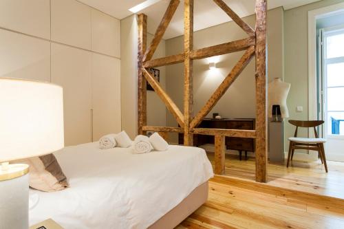 Een bed of bedden in een kamer bij JOIVY Deluxe 3BR Apt with workspace by Figueira Sq and Rossio subway