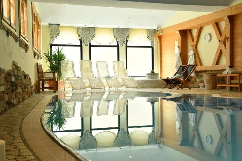 a swimming pool with chairs in a room at Hotel Pangrazzi in Fucine