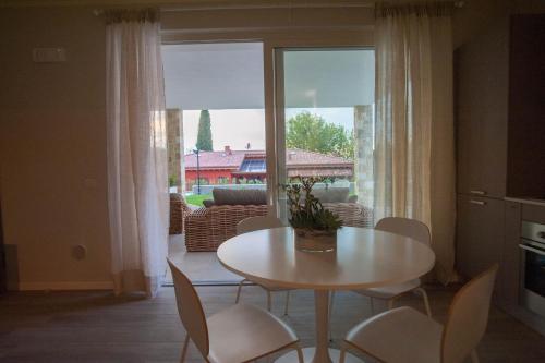 a dining room with a table and chairs and a large window at Italianflat - Maison du Lac in Lazise
