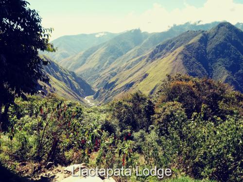a view of a mountain range with a valley at Llactapata Lodge overlooking Machu Picchu - camping - restaurant in Salcantay