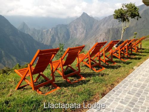a row of orange chairs sitting on top of a mountain at Llactapata Lodge overlooking Machu Picchu - camping - restaurant in Salcantay