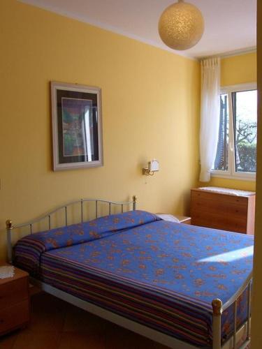 a bedroom with a bed with a blue comforter at Casa Gialla in Imperia