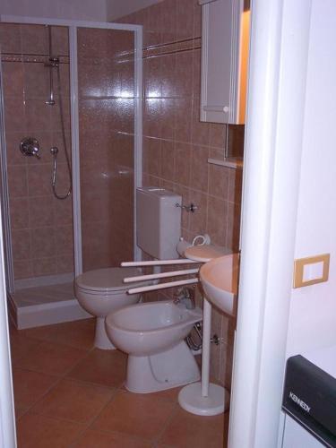 a bathroom with two toilets and a shower and a sink at Casa Gialla in Imperia