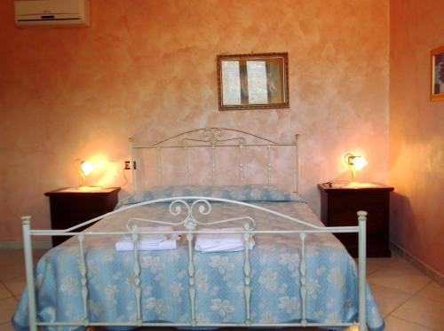 a bedroom with a bed with two lamps on two tables at Dolcedorme Bed And Breakfast in Terranova di Pollino