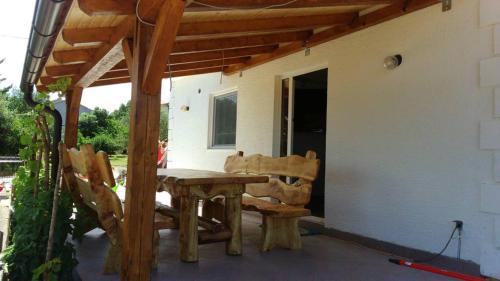 einen Holztisch und Stühle auf einer Terrasse in der Unterkunft Tajči in Ugljan