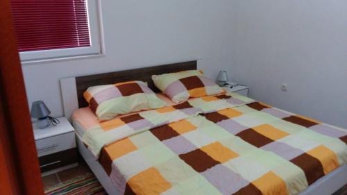 ein Schlafzimmer mit einem Bett mit einer bunten Decke in der Unterkunft Tajči in Ugljan