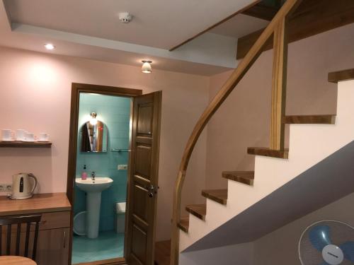 a staircase leading to a bathroom with a sink and a toilet at Vila Saulė in Palanga