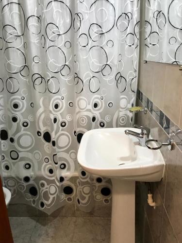 a bathroom with a sink and a shower curtain at Departamentos temporarios Mirasol lll Federaciòn in Federación