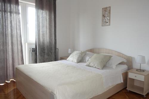 - un lit blanc dans une chambre avec fenêtre dans l'établissement L.P.M. Apartments, à Nin