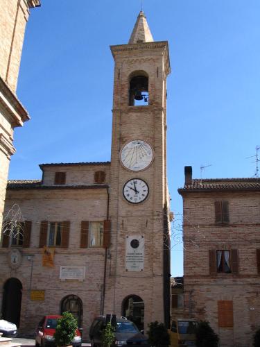 a tall tower with a clock on a building at Hotel Rivamare in Massignano