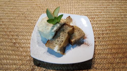 a white plate with a piece of cake with a green leaf on it at El Rincon Eco Hotel in Los Ángeles