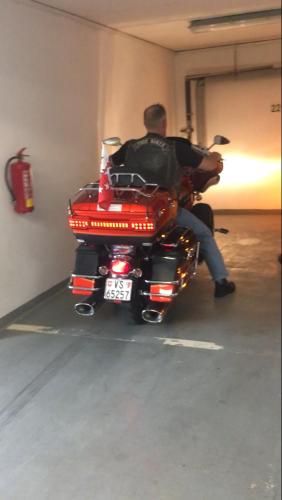 a man sitting on a motorcycle in a garage at Pension Karnet in Prague