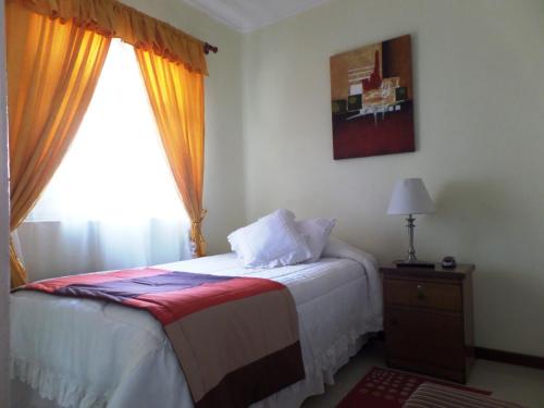 a bedroom with a bed with a window and a table at Gran Hotel Ovalle in Ovalle
