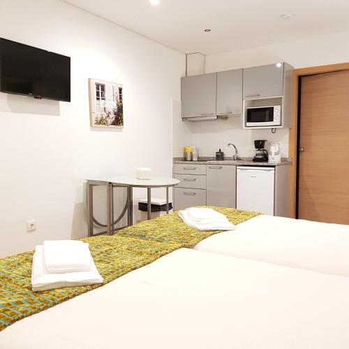 two beds in a room with a kitchen at À Francos Metro in Porto