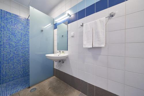 a blue and white bathroom with a sink and a mirror at Marina Rooms in Calheta