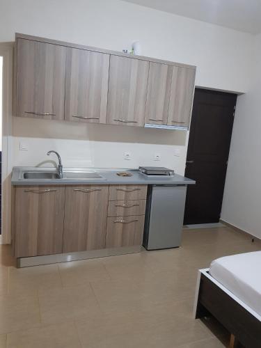 a kitchen with wooden cabinets and a sink at Vila DINI Ksamil in Ksamil
