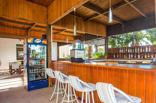 a bar with white chairs and a refrigerator at Mon Repos Hotel in Faliraki