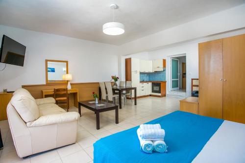 a living room with a white couch and a table at Mon Repos Hotel in Faliraki