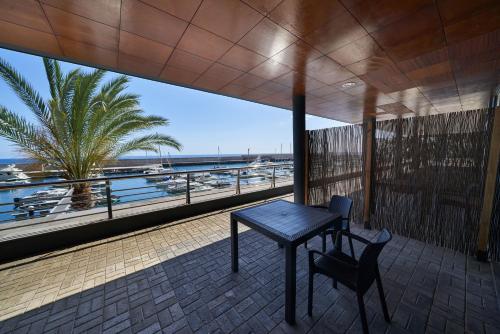 a table and chair on a balcony with a view of the beach at Marina Rooms in Calheta