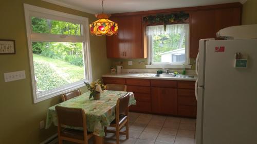 a kitchen with a table and a refrigerator at 2 bedroom Wiffen Cottage in Port Albert
