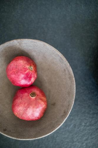 two red apples sitting in a wooden bowl at Kräutererbe Bacherhof in Nalles
