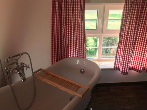 a bath tub in a bathroom with a window at Landhaus zum Storchennest in Kloster Wulfshagen