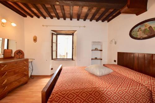 1 dormitorio con 1 cama, vestidor y ventana en Luciano e Norma House Il Rustico, en Gerfalco
