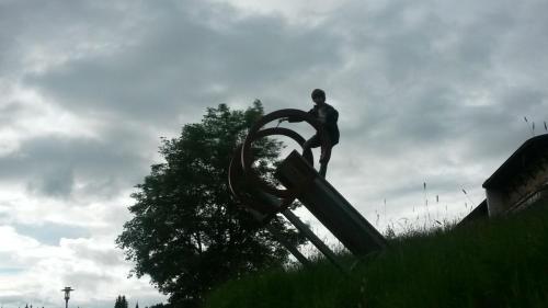 a statue of a man standing on a object in a field at Jungholz Erlebnis in Jungholz