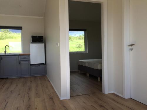 クヴァンムスタンギにあるHvammstangi Hill Homesのキッチン、シンク、ベッド1台が備わる客室です。
