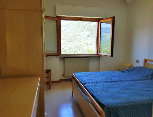Un dormitorio con una cama azul y una ventana en Casa Vacanze Sia, en Caramanico Terme