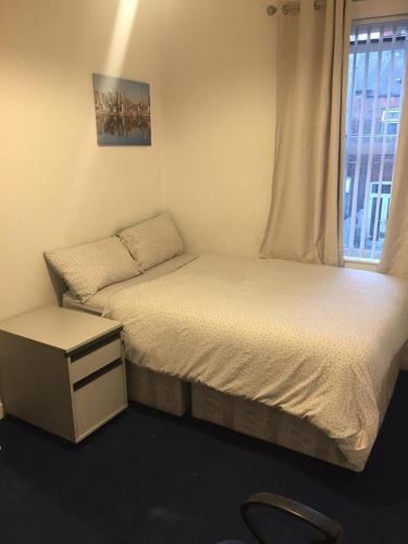 ein kleines Schlafzimmer mit 2 Betten und einem Fenster in der Unterkunft Double Room Home Stay Manchester in Manchester