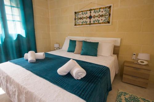 a bedroom with a bed with towels on it at Maxija B&B - Palm in Għarb
