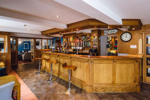 a large bar with a large clock on the wall at Elan Hotel in Rhayader
