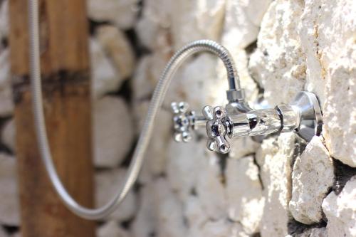 a shower head attached to a stone wall at The Calmtree Bungalows in Canggu