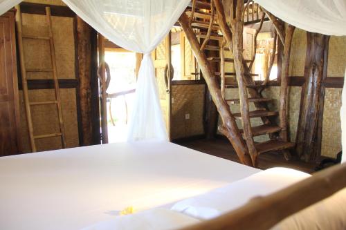 a bedroom with a bed and a canopy at The Calmtree Bungalows in Canggu