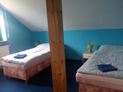 two twin beds in a room with blue walls at U nových přátel in Lichkov