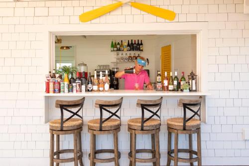 a man standing behind a bar with stools at Yachtsman Lodge & Marina in Kennebunkport