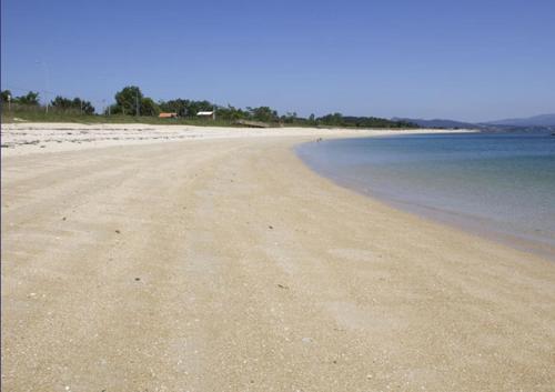 una playa vacía con el océano en el fondo en Apartamento de playa, en Boiro