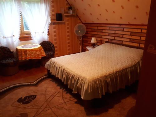 a bedroom with a bed and a table and a window at Olsik in Białowieża
