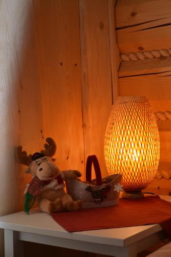 a stuffed bear sitting on a table next to a lamp at Leśniówka Domki W Karpaczu in Karpacz