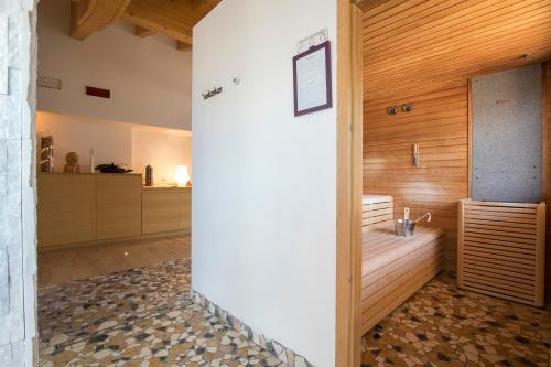 a bathroom with a shower with a wooden wall at Hotel Luna Bianca Folgaria in Folgaria